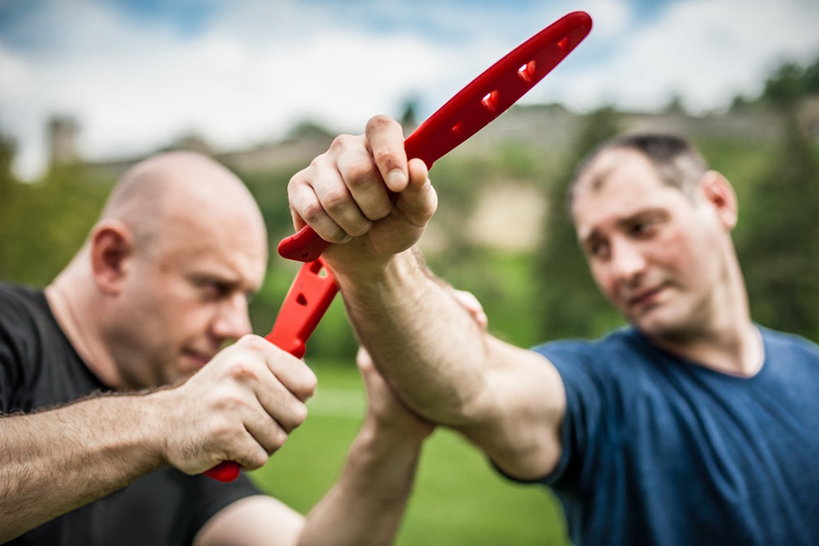 Knife vs knife fight. Kapap instructor demonstrates martial arts self defense fighting and disarming technique. Weapon retention and disarm training
